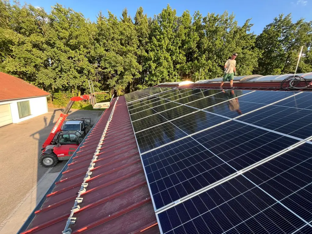 PV-Anlage auf rotem Trapezblechdach einer Halle – Elektrotechnik Hochbrandner